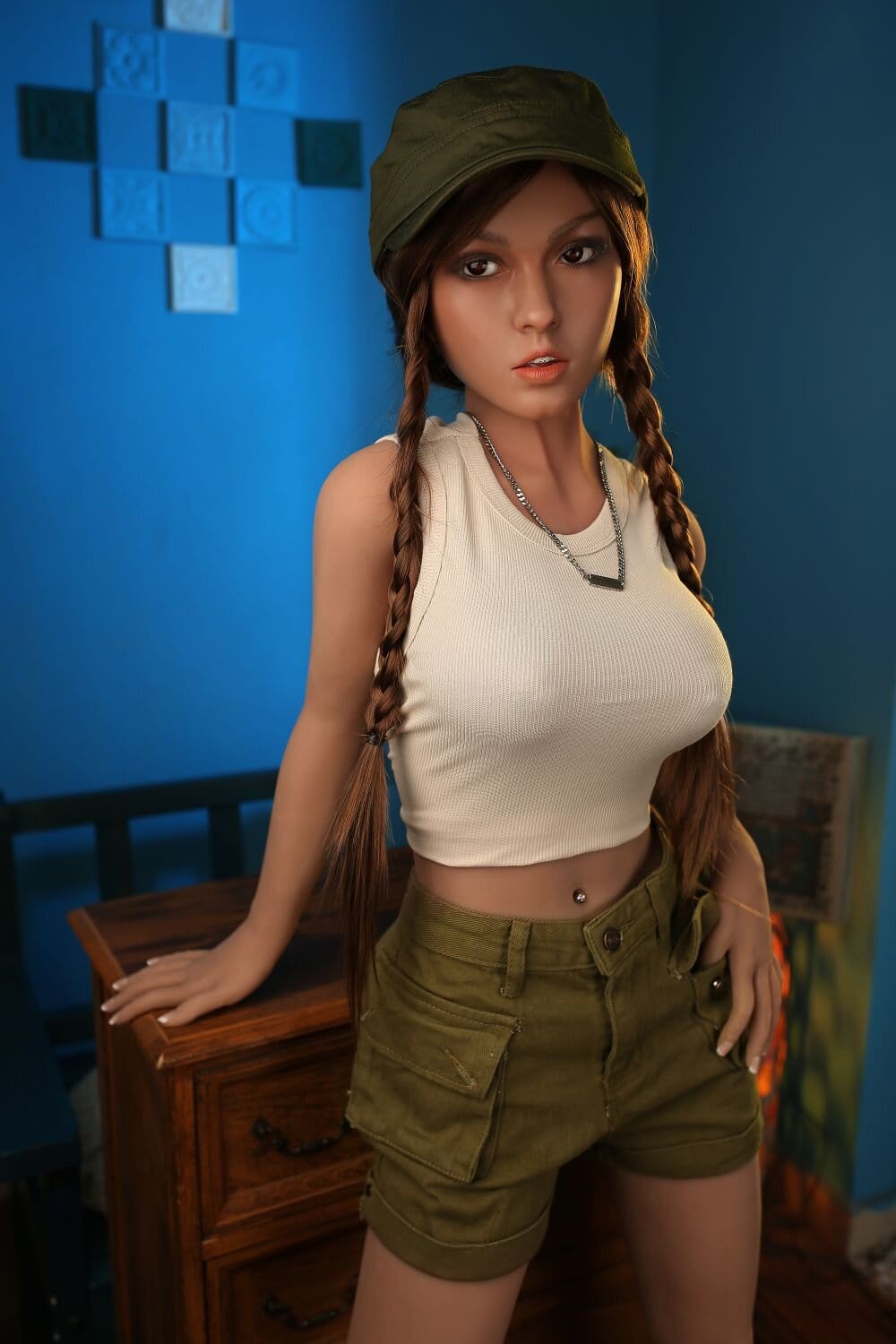 Beautiful woman with braided hair wearing a military cap and casual outfit in a studio setting.